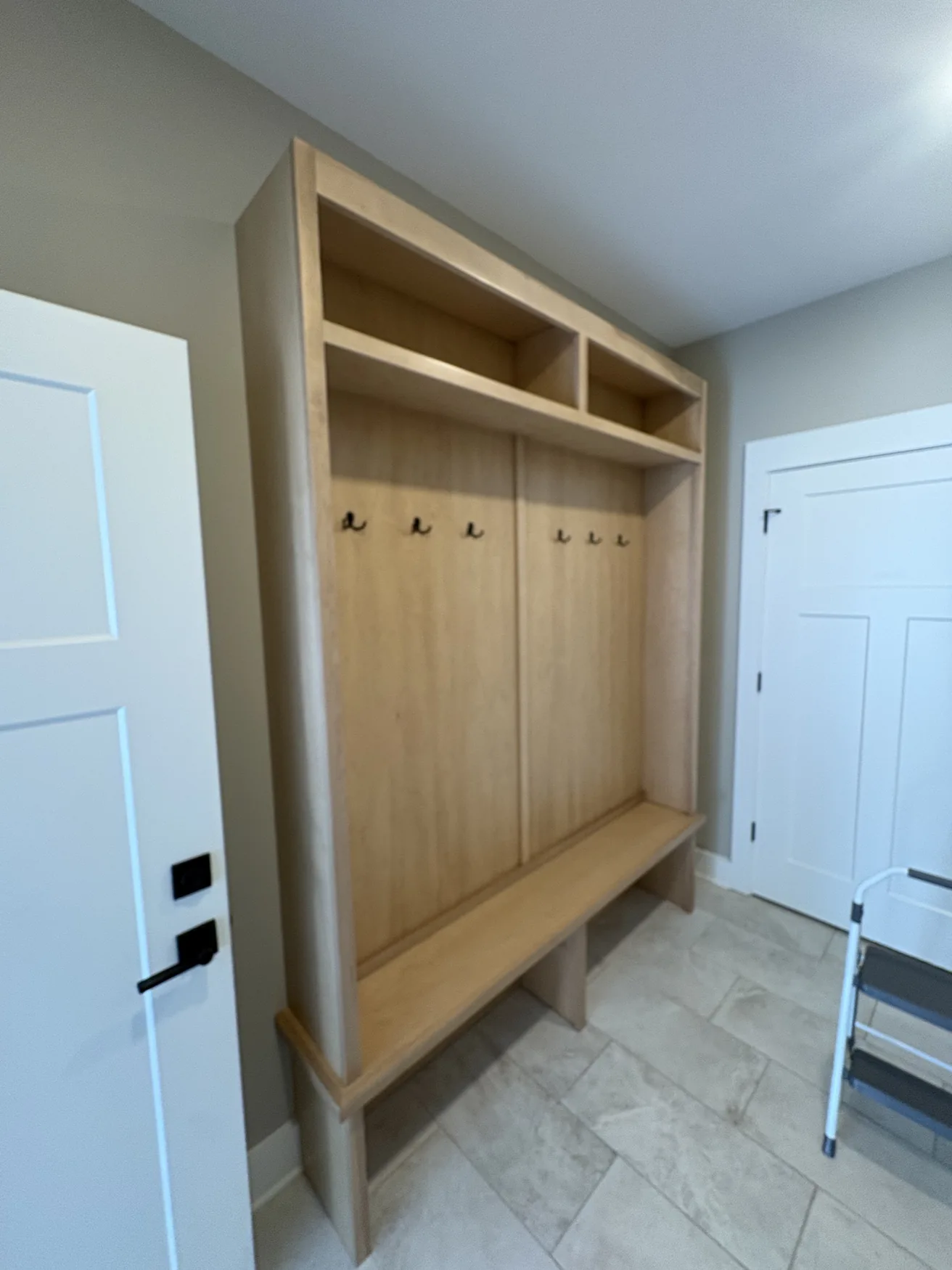 Natural wood bench and cubbies fitted into an entryway