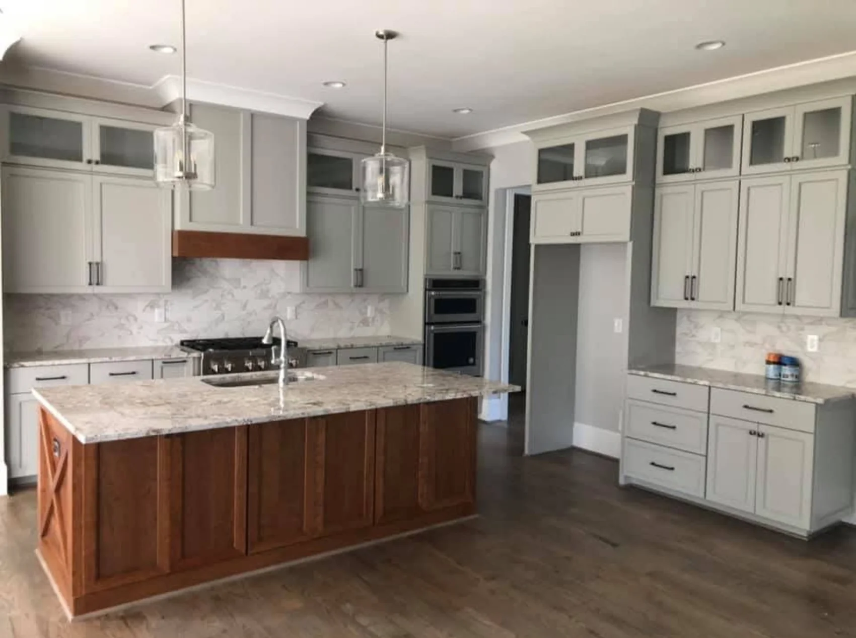 White and gray fitted cabinetry with a contrasting natural wood island